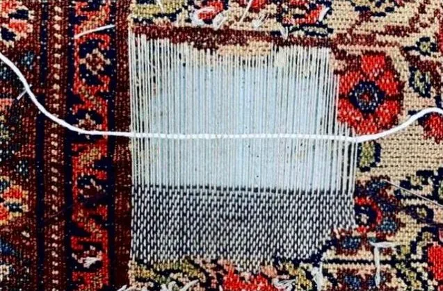 Retissage d’une lacune : la fondation reposée fil à fil sur un tapis ancien